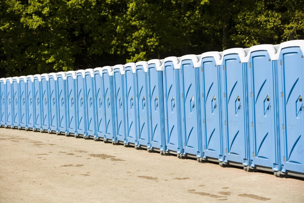 long pile of blue portable toilets
